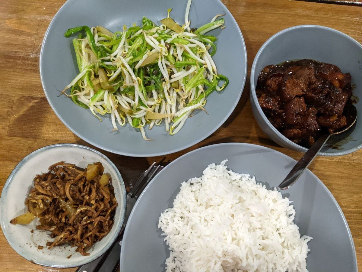 A homestyle Chinese dinner set on a wooden table.
